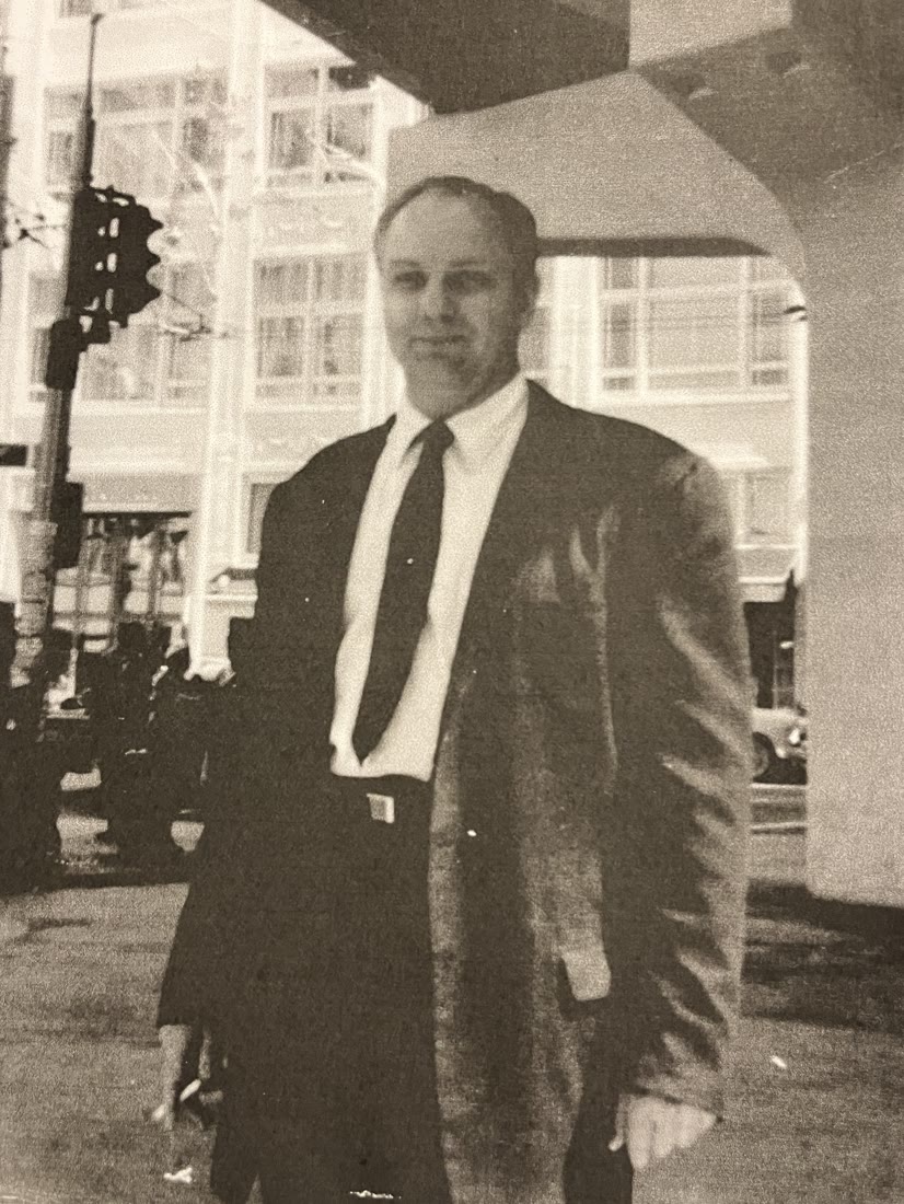 Ted Owens in a suit and tie on a city street.